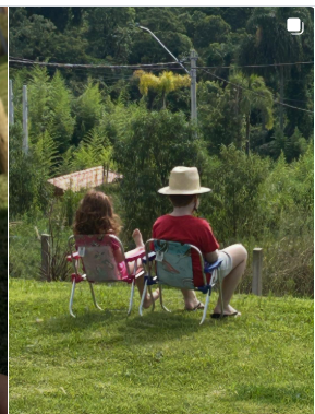 Dois pessoas sentadas contemplando o horizonte verde